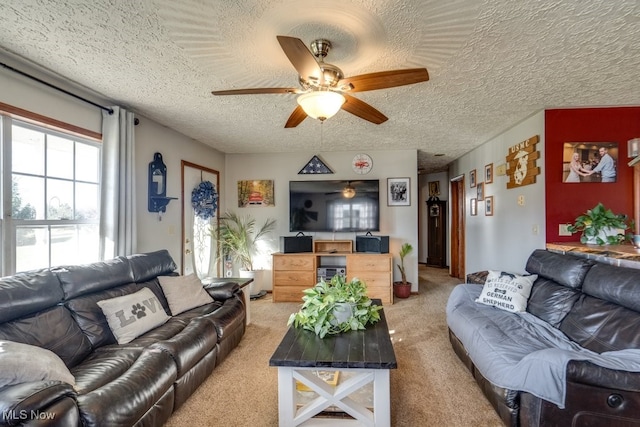 carpeted living room featuring ceiling fan and a textured ceiling