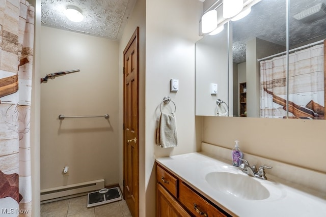 bathroom featuring tile patterned flooring, vanity, a textured ceiling, and baseboard heating