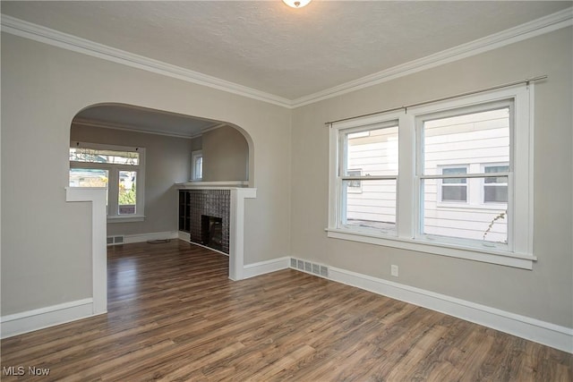 unfurnished living room featuring a textured ceiling, dark hardwood / wood-style flooring, and crown molding