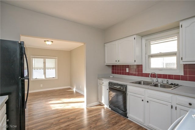 kitchen with black appliances, white cabinets, sink, and tasteful backsplash