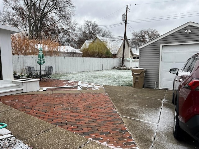 view of patio with a garage and an outbuilding