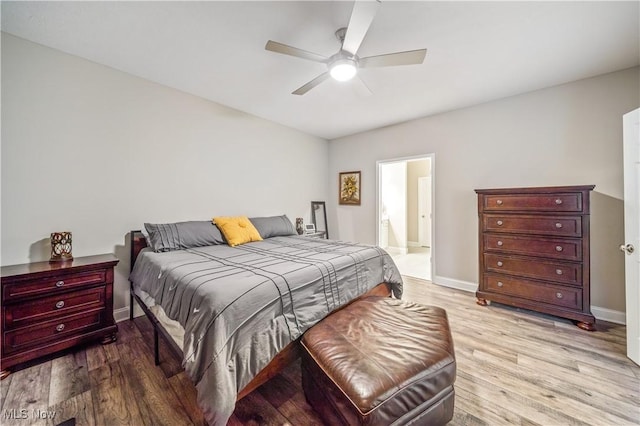 bedroom with ceiling fan, ensuite bath, and light hardwood / wood-style flooring