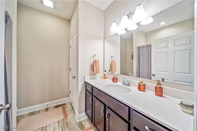 bathroom with hardwood / wood-style floors, vanity, and toilet