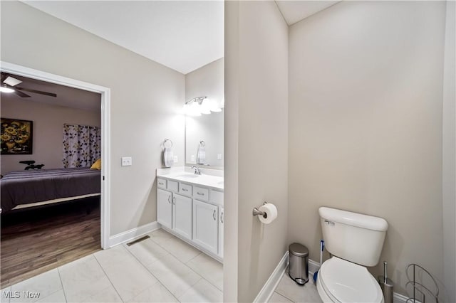 bathroom featuring tile patterned flooring, vanity, ceiling fan, and toilet