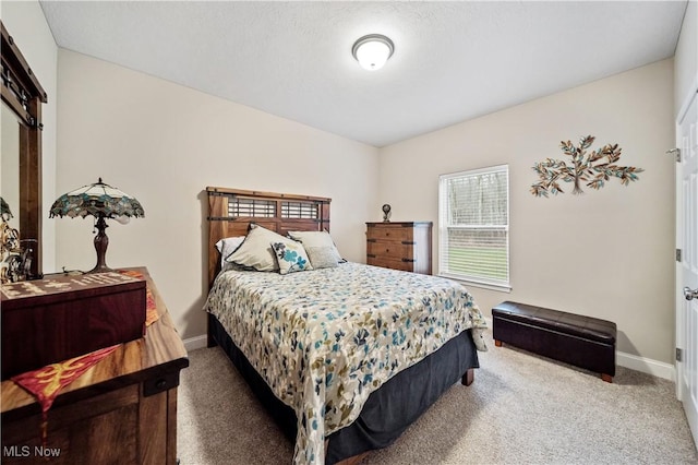 carpeted bedroom featuring a barn door