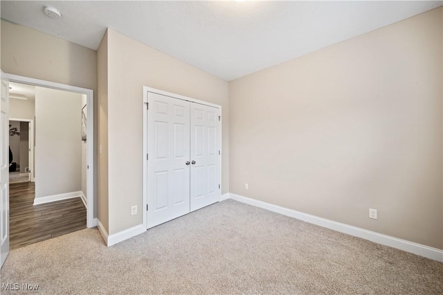 unfurnished bedroom featuring carpet flooring and a closet