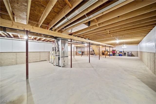 basement with heating unit and brick wall