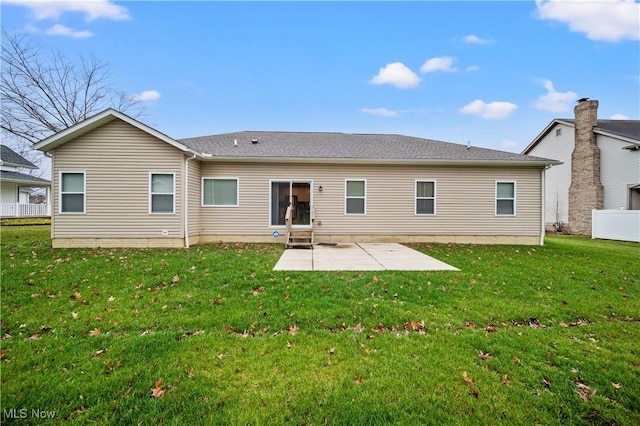 rear view of house featuring a patio area and a yard