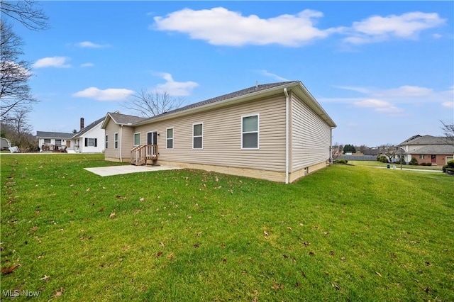 back of house with a yard and a patio