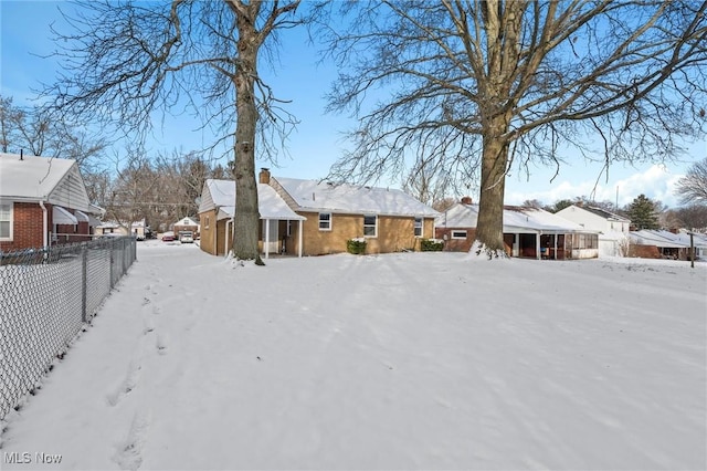 view of snow covered back of property