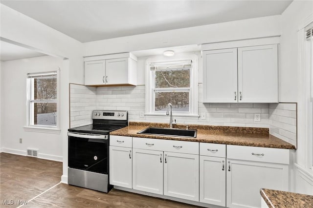 kitchen with white cabinetry, sink, dark wood-type flooring, backsplash, and stainless steel range with electric cooktop