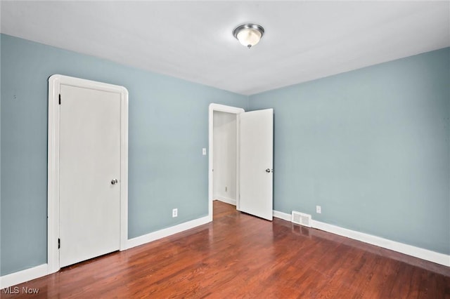 empty room featuring dark wood-type flooring