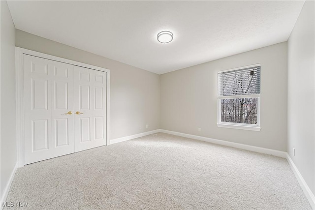 unfurnished bedroom featuring carpet flooring and a closet