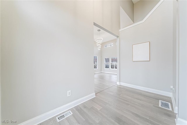 interior space with a high ceiling and light hardwood / wood-style flooring