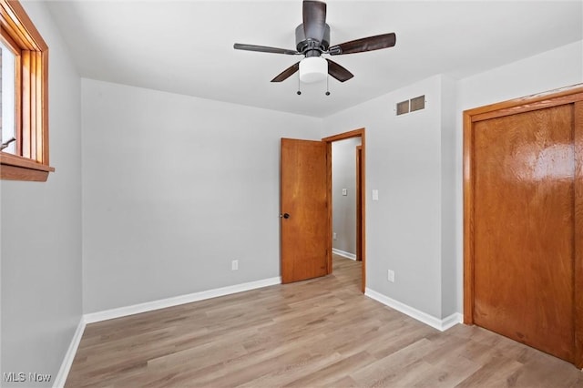 unfurnished bedroom with a closet, light hardwood / wood-style floors, and ceiling fan