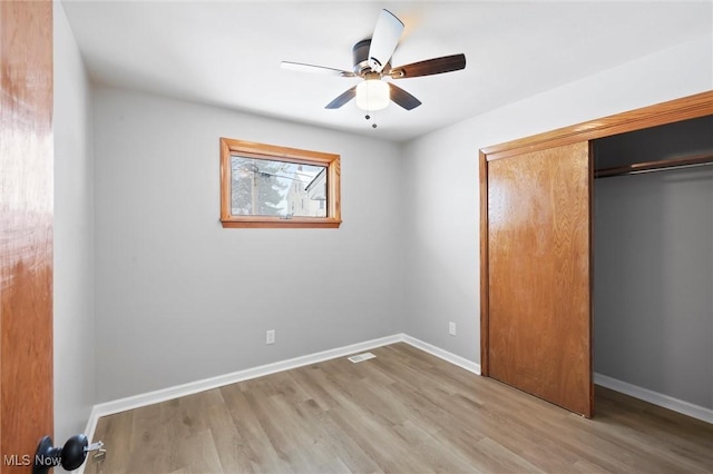 unfurnished bedroom with ceiling fan, a closet, and light hardwood / wood-style flooring