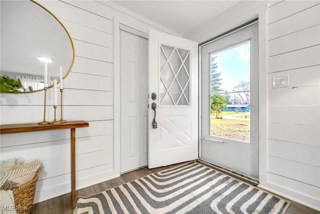 doorway featuring wooden walls and dark hardwood / wood-style flooring