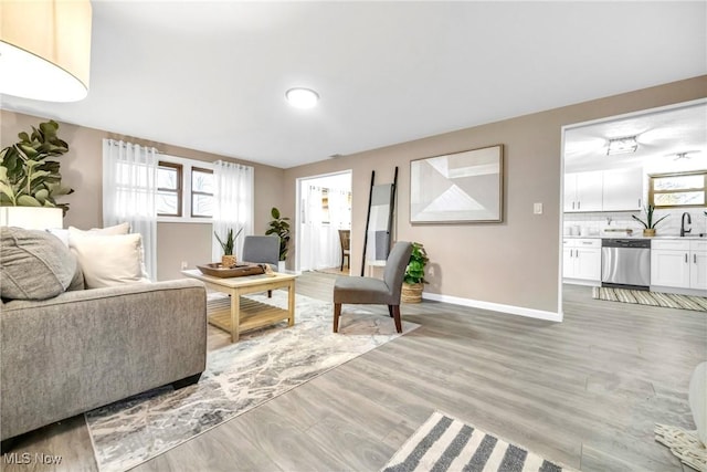 living room with light hardwood / wood-style floors and sink