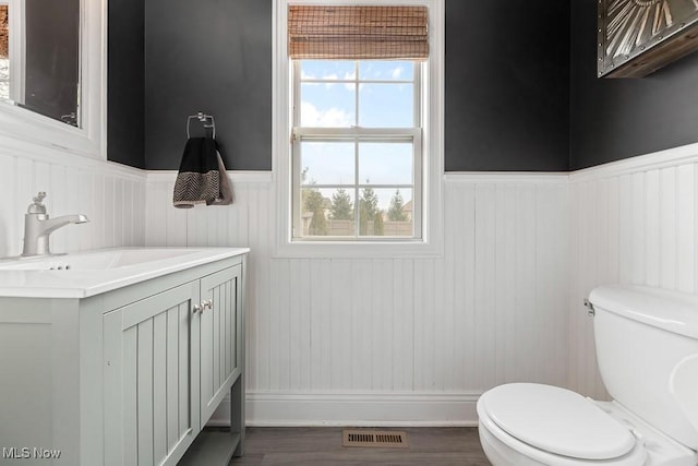 bathroom with plenty of natural light, toilet, and vanity