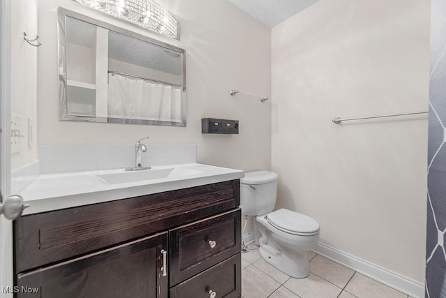 bathroom with a textured ceiling, vanity, toilet, and tile patterned floors