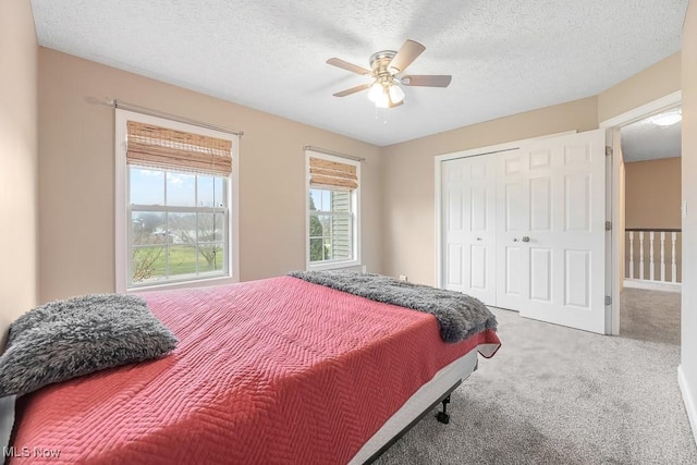 bedroom with carpet, ceiling fan, a textured ceiling, and a closet