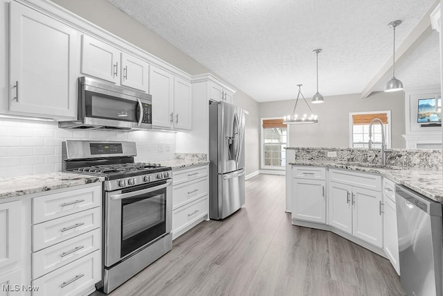 kitchen featuring decorative backsplash, appliances with stainless steel finishes, pendant lighting, beamed ceiling, and white cabinetry