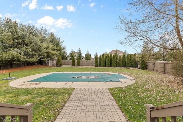 view of swimming pool with a lawn, a patio area, and a shed