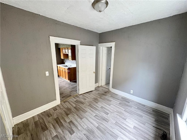 unfurnished bedroom featuring light hardwood / wood-style flooring and a textured ceiling