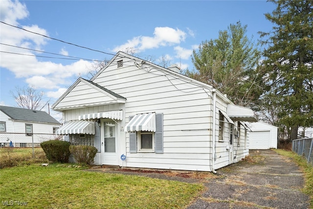 exterior space with a garage, an outdoor structure, and a front yard