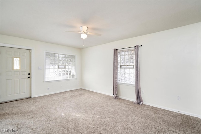 carpeted spare room featuring ceiling fan