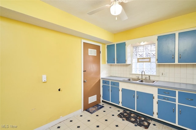 kitchen with ceiling fan, blue cabinets, sink, and tasteful backsplash