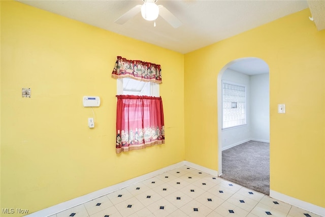 carpeted spare room featuring ceiling fan