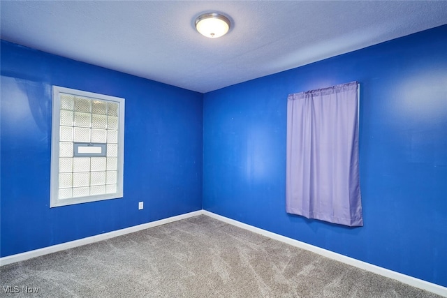 carpeted spare room with a textured ceiling