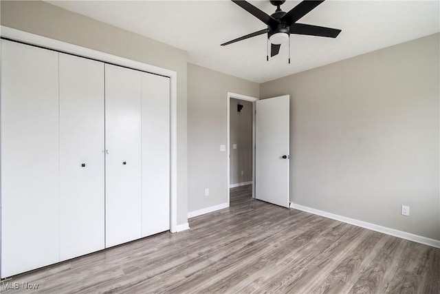 unfurnished bedroom featuring ceiling fan, light hardwood / wood-style flooring, and a closet