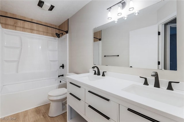 full bathroom with hardwood / wood-style floors, vanity, toilet, and shower / washtub combination