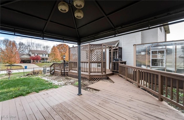 wooden deck featuring a gazebo and a lawn