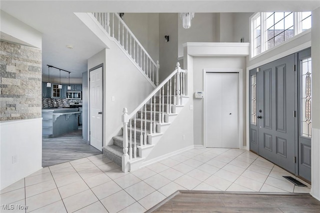 foyer with light tile patterned floors and a high ceiling