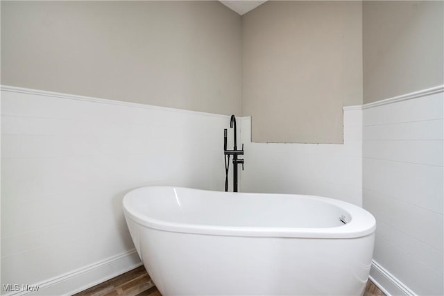 bathroom featuring a washtub and hardwood / wood-style floors