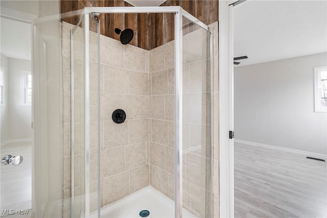 bathroom with hardwood / wood-style flooring and a shower with shower door