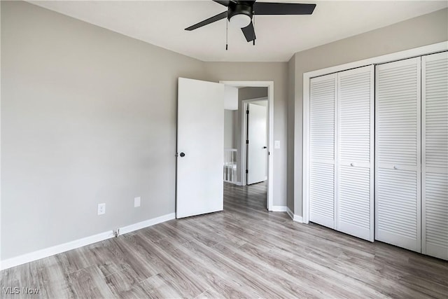 unfurnished bedroom with ceiling fan, light hardwood / wood-style flooring, and a closet