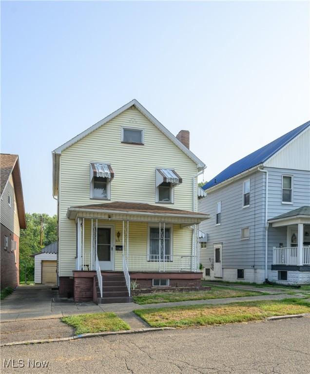 view of front facade with covered porch and an outbuilding