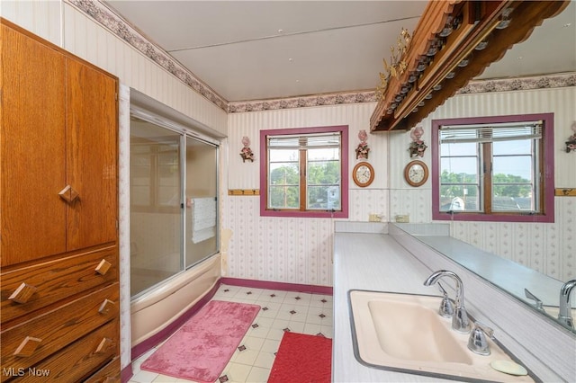 bathroom with shower / bath combination with glass door and sink