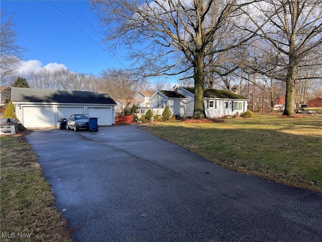 view of side of home featuring a lawn, an outbuilding, and a garage