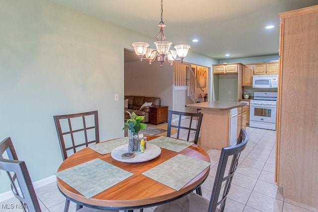 dining space with light tile patterned floors and an inviting chandelier