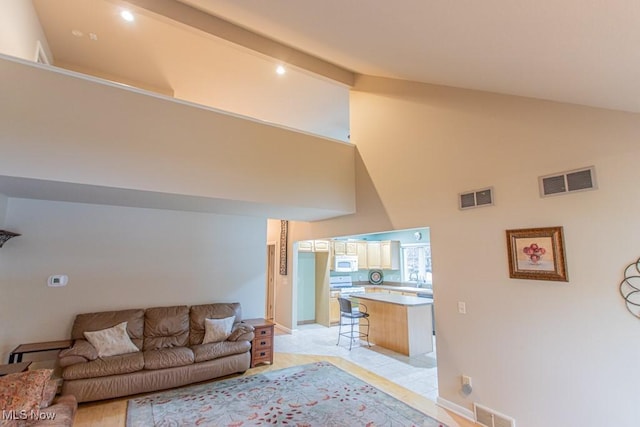 tiled living room featuring high vaulted ceiling