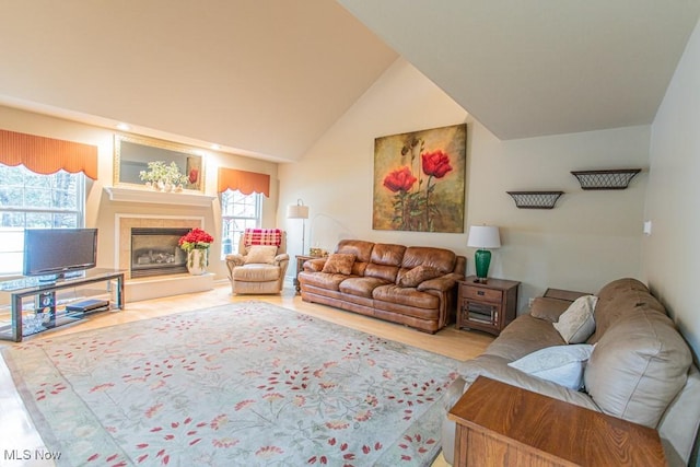 living room with vaulted ceiling and a tiled fireplace