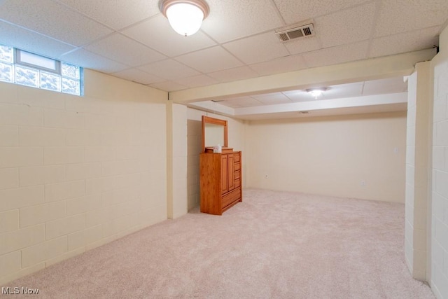 basement with a drop ceiling and carpet