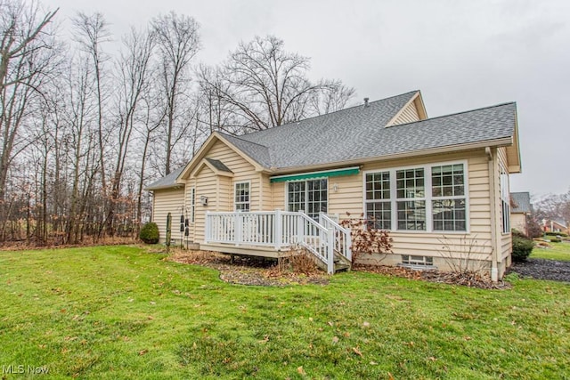 rear view of house with a lawn and a wooden deck