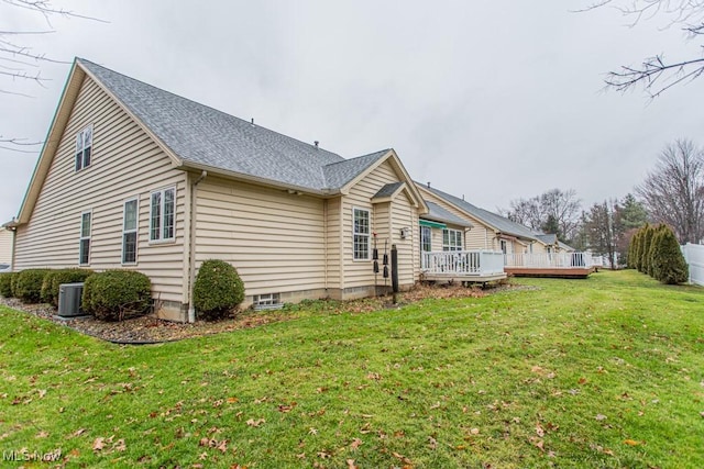 view of property exterior with central air condition unit, a deck, and a lawn