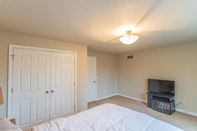 bedroom with light carpet and a closet